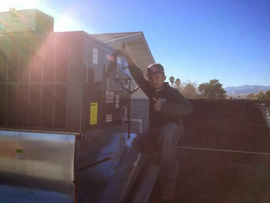 HVAC technician performing AC Tune-Up on a rooftop unit in South Williamsport